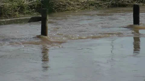 Close on fence posts in fast flowing flood waters 動画素材 12591470