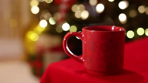 A Close Up Of A Festive Red Mug with Steam on Holiday Table Stock Footage 313711278