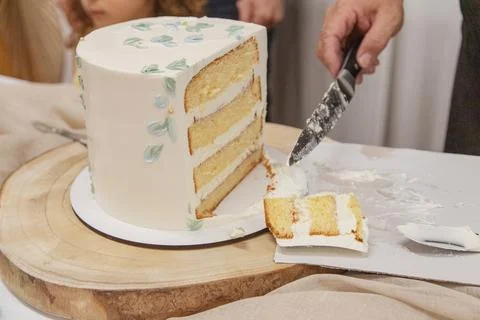 Close-up of a festive sponge cake being sliced and served by hand Stock Photos