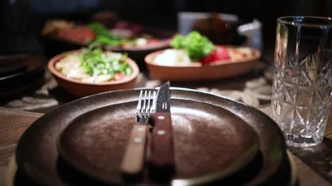 Close-up of a festive table setup with glasses, white plates. Stock Footage 344744671