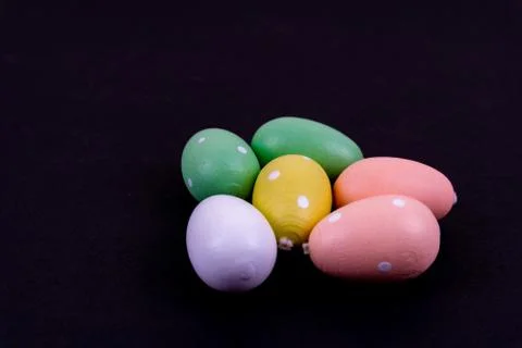 Close up of a few colorful easter eggs laying on black background Stock Photos