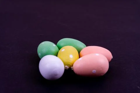 Close up of a few colorful easter eggs laying on black background Stock Photos