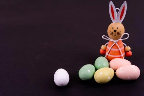 Close up of a few colorful easter eggs and a easter bunny on black background Stock Photos