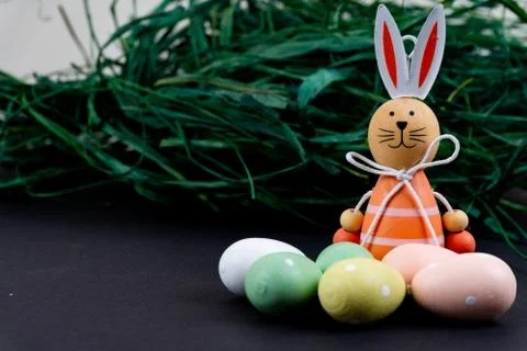 Close up of a few colorful easter eggs, a easter bunny and easter grass on bl Stock Photos