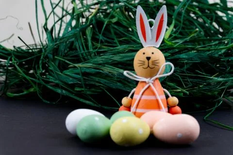 Close up of a few colorful easter eggs, a easter bunny and easter grass on bl Stock Photos