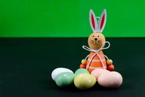 Close up of a few colorful easter eggs and a easter bunny on black background Stock Photos