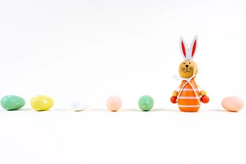 Close up of a few colorful easter eggs and a easter bunny on white background Stock Photos
