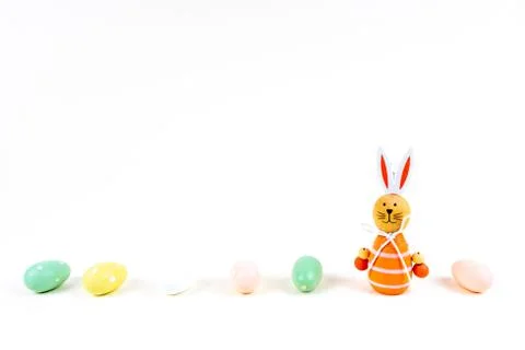 Close up of a few colorful easter eggs and a easter bunny on white background Stock Photos