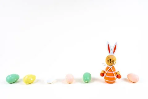 Close up of a few colorful easter eggs and a easter bunny on white background Stock Photos