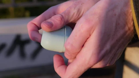 Close-up of fidgeting hands with earbud case Stock Footage 320556252