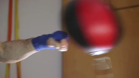 Close-up fighter's hands in boxing wraps punching double end striking bag. Stock Footage 104879373