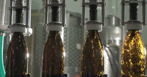 Close-up of filling bottles with red wine by the machine. Wine bottling process Stock Footage 249900633