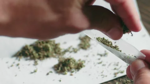 Close filming of man's hands during he prepare a marijuana joint, from his side Video stock 162500301