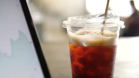 Close-up of financial candlestick chart on tablet screen withiced coffee Video stock 332359686