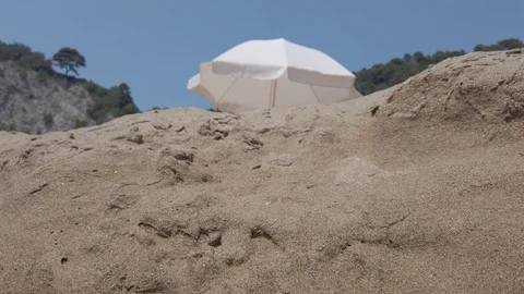 Close up fine sand and beach umbrella in the background 4k Stock Footage 122046811