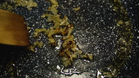 Close-up of finely chopped onions being sautéed in a frying pan with oil. Stock Footage 332699088