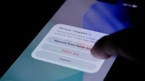 Close up of finger deleting chatgpt icon on smartphone screen, showing modern Stock Footage 334059848