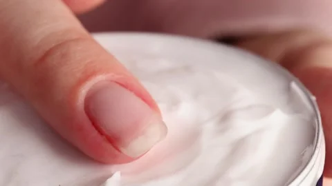 Close-up of a finger dipping into a moisturizing cream in a metal tin, soft Video stock 304679349