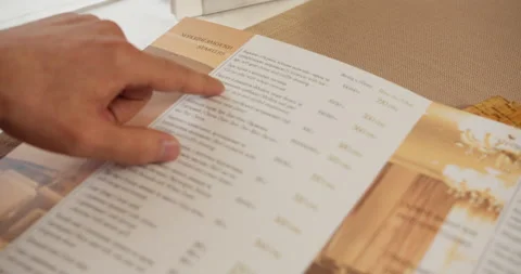 Close-up finger guides through the menu list in hotel restaurant Stock Footage 229552677