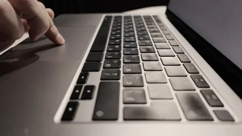 Close-up of a finger interacting with a laptop touchpad and keyboard, Stock Footage 339174472