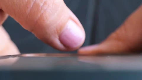 Close-up of a finger interacting with a touchscreen device in natural light Vidéo 285667152