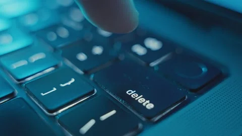 Close up on finger presses on Delete key on laptop keyboard in dark office room Stock Footage 340234136