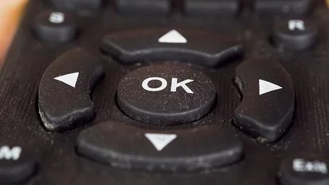 Close-up finger presses OK button on remote Stock Photos