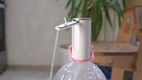 Close-up of a finger pressing a button on an electric water pump, pouring water Video stock 319502541