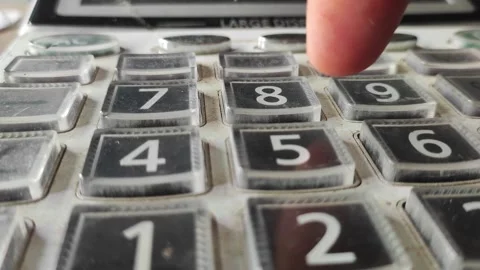 Close up of a finger pressing buttons on a calculator keypad for financial Stock Footage 345072326