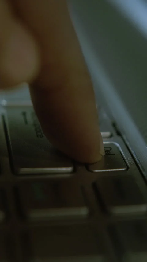 Close-up of a Finger Pressing the Delete Key on a Laptop Keyboard in Low Li.. Stock Footage 303739932