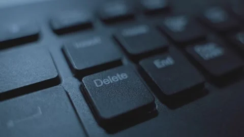 Close up on finger pressing Delete key on computer keyboard in dark office Video stock 332964746
