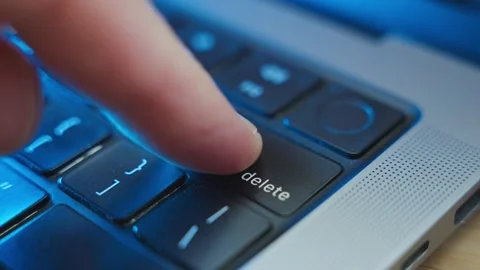 Close up on finger pressing the Delete keypad on laptop computer keyboard in Stock Footage 345278228