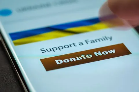 Close-up finger pressing donate button on smartphone screen. Donation money Fotos de archivo