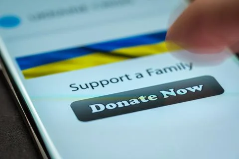 Close-up finger pressing donate button on smartphone screen. Donation money Photos