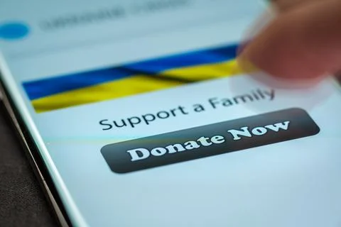 Close-up finger pressing donate button on smartphone screen. Donation money Foto stock