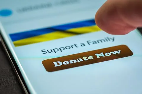 Close-up finger pressing donate button on smartphone screen. Donation money 스톡 사진