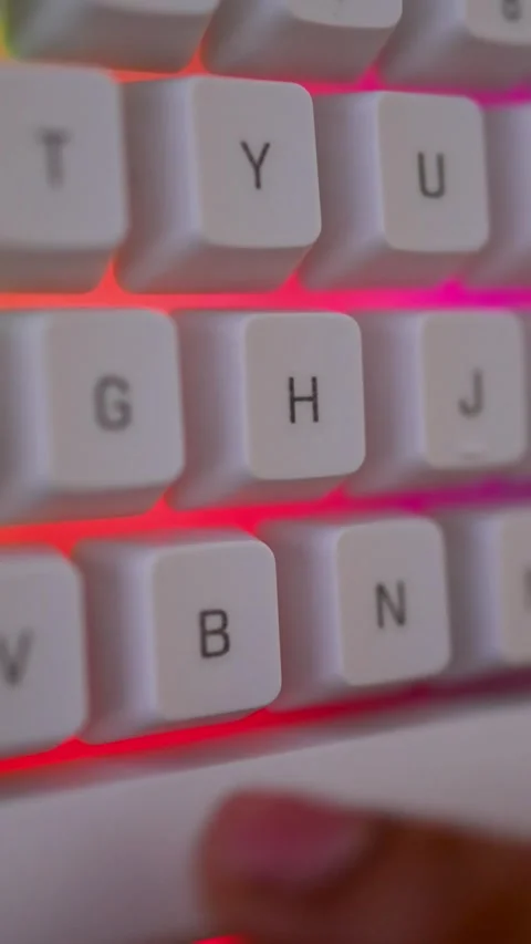 Close-up of a finger pressing a key on a backlit keyboard with green and re.. Stock Footage 315982172