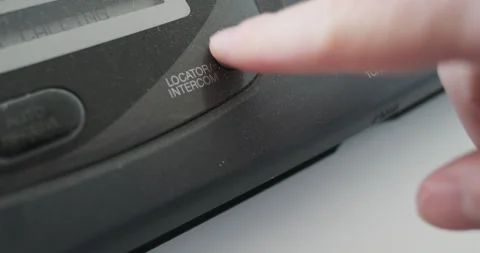 Close-up, finger pressing locator intercom button on an old fax machine, analog Video stock 289550635