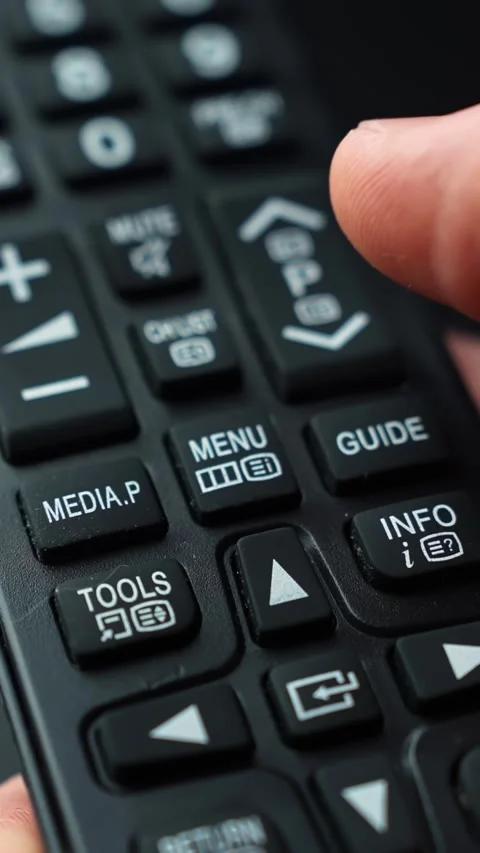 Close-up finger pressing MENU on a TV remote, shallow depth of field and cozy Stock Footage 329479261