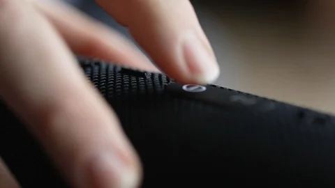 Close up of finger pressing power button to a speaker Stock Footage 106403126