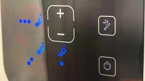 Close-Up of Finger Pressing Power Button on Digital Water Heater Control Panel 스톡 동영상 345010095