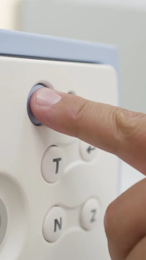 Close-up of a finger pressing the power button on a medical device panel Stock Footage 345703371