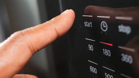 Close up of finger pressing start button on microwave oven, timer set to 18.. Stock Footage 333151857