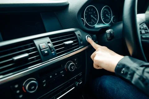 Close up of finger pressing the start stop engine button on car Foto stock