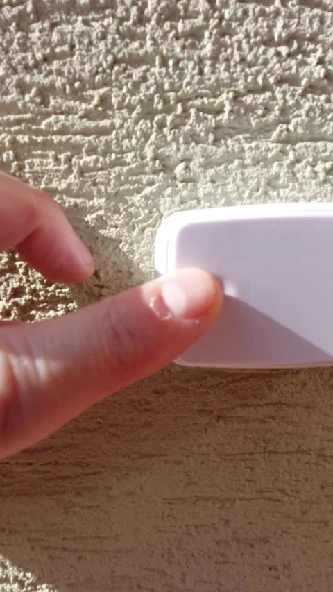 Close-up of a finger pressing a white wireless doorbell button Vídeos de archivo 333644175