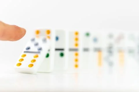 Close-up of finger push a block on a line of domino. Risk and strategy in bus Stock-Fotos