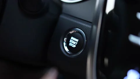 Close up of finger pushing orange start engine button in a car Stock Footage 221239239