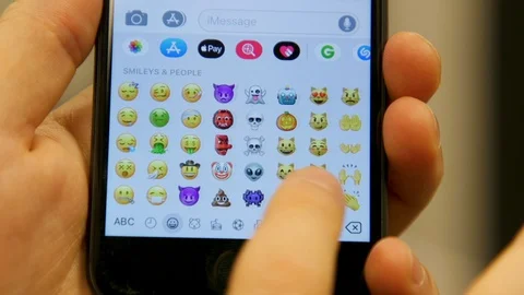 Close up of Finger Scrolling on all the Emojis on Mobile Phone Message App Stock Footage 127774239