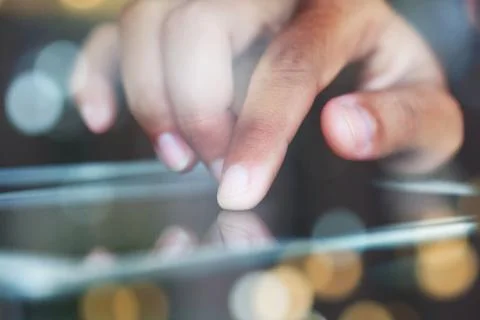 Close-up finger touching on communicator electronic device on night Stock Photos