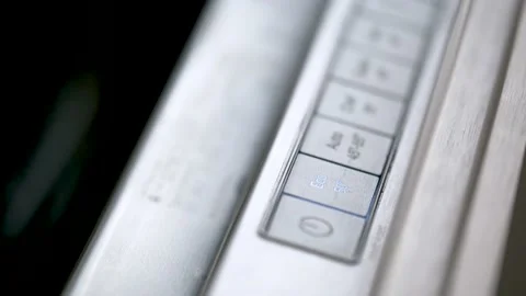 Close-up of finger turning on in eco function a modern dishwasher. 스톡 동영상 231858618